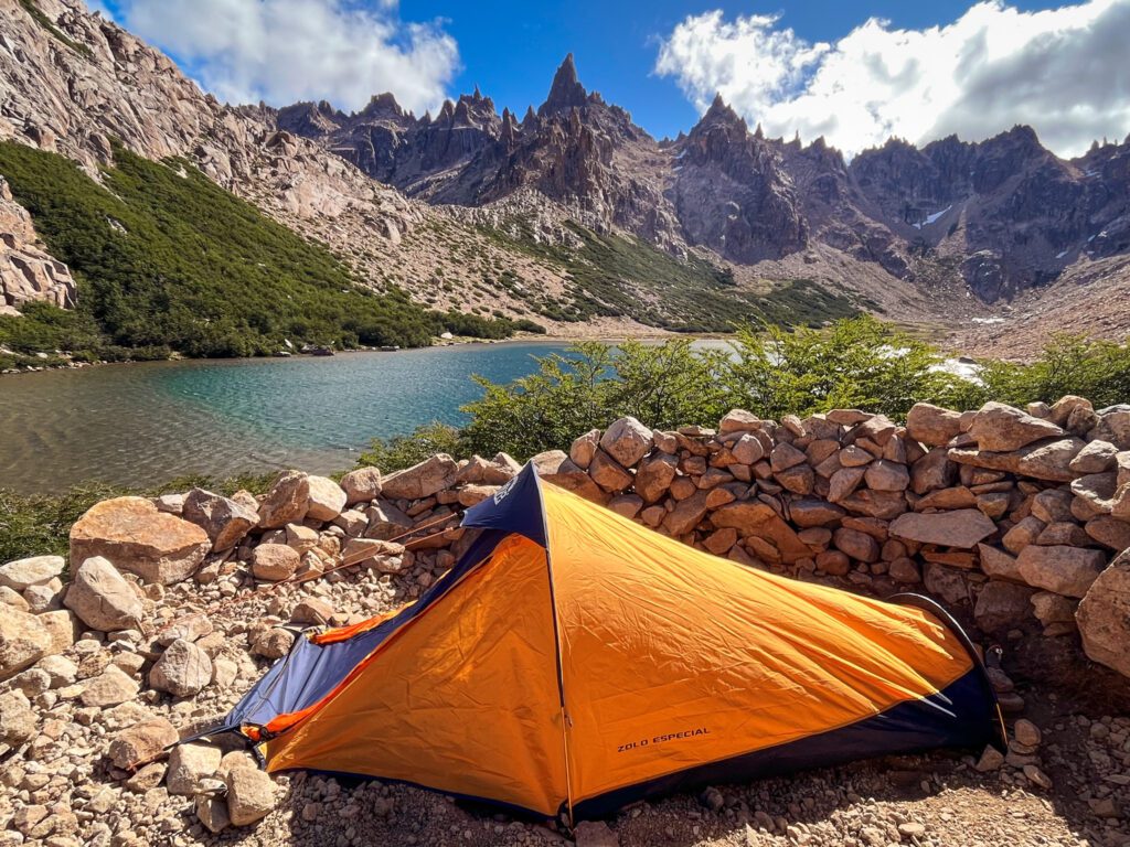 a backpacking tent pitched next to an alpine lake