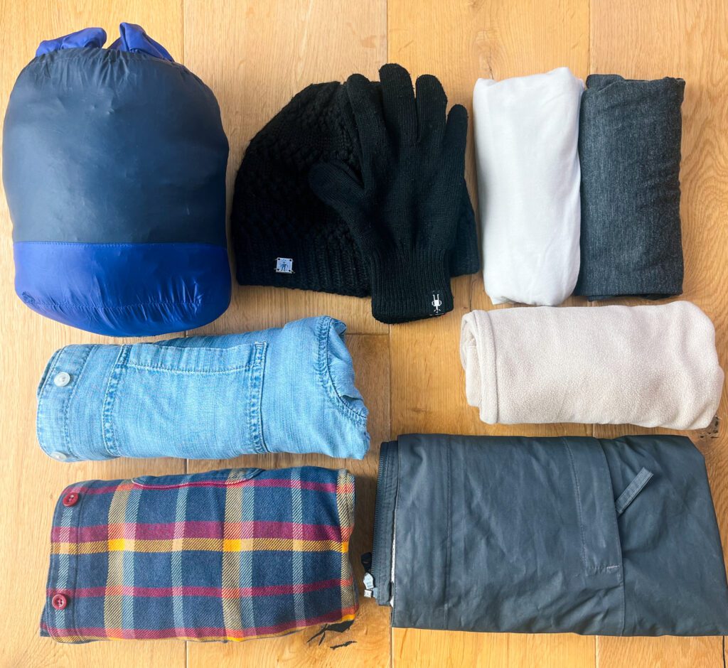 a spread of layers and cold weather clothes for a travel packing list.