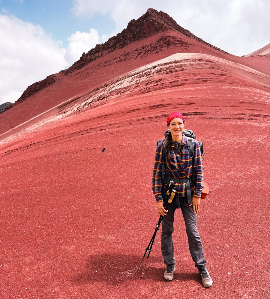 a backpacker in front of a red mountain