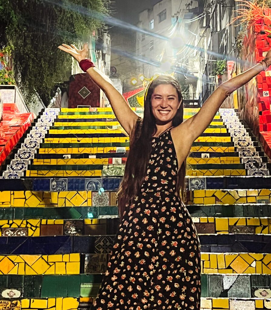 a woman in front of a colorful staircase in Brazil.