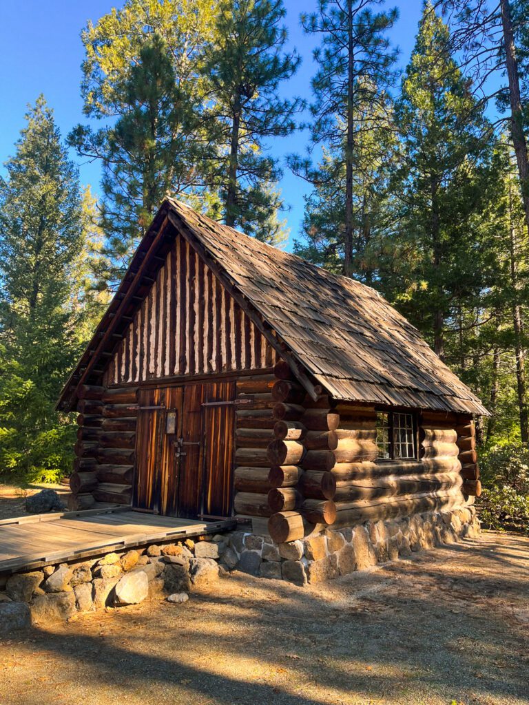 a historic log cabin in the forest