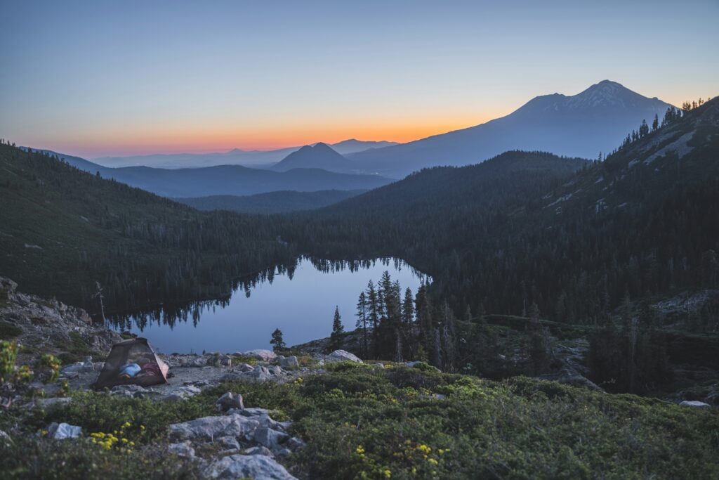a tent pitched overlooking heart lake and mt shasta in california