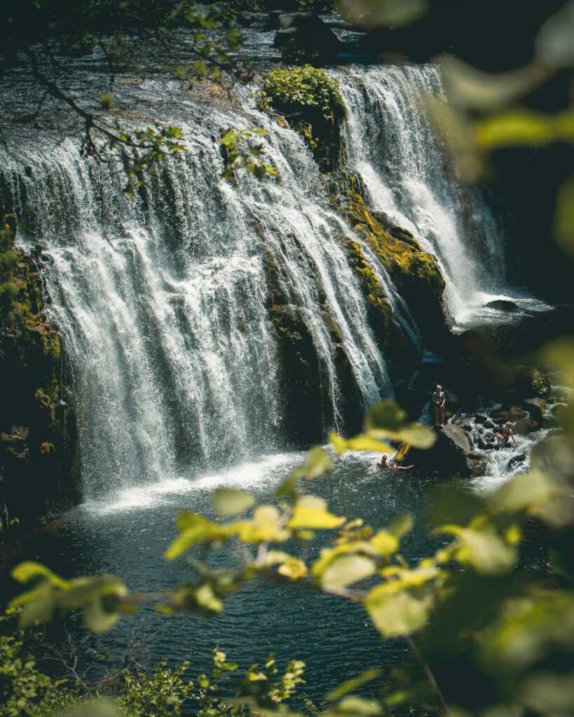 a wide waterfall cascading down a mossy cliff