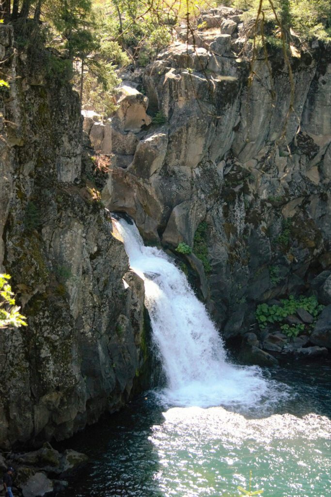 a waterfall cascading from a basalt column gorge