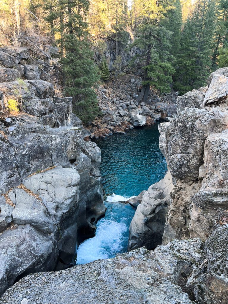 a view from the top of a waterfall in the forest