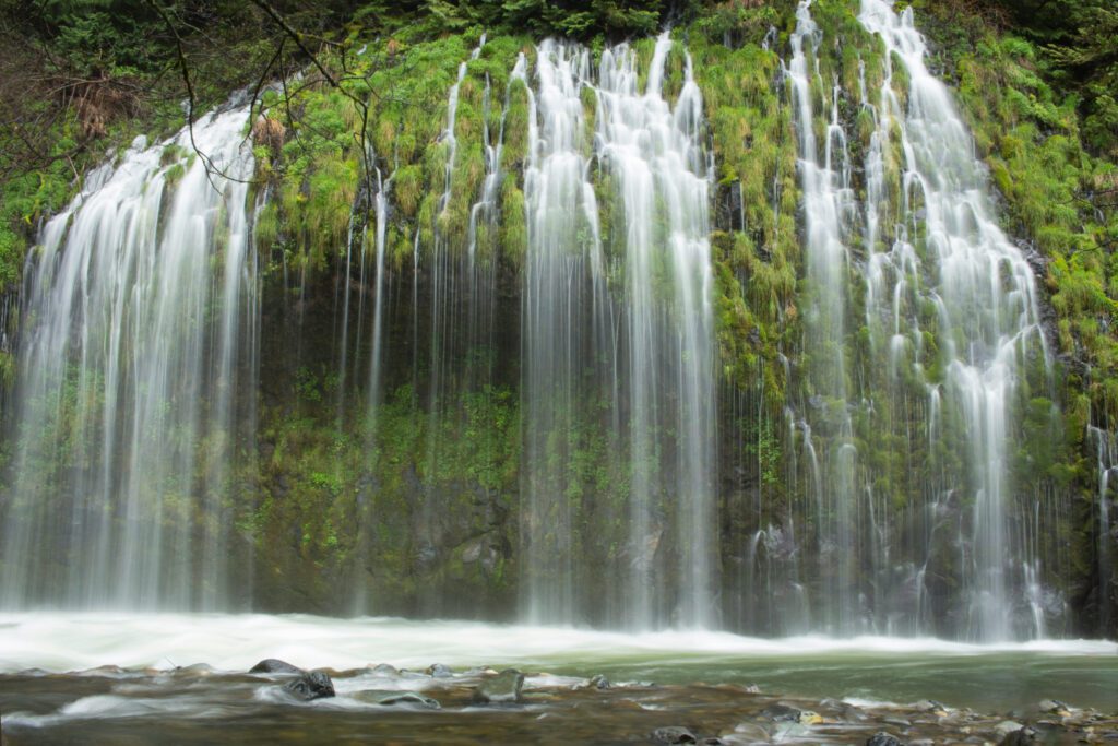 A wide waterfall consisting of delicate streams cascading down a mossy surface.