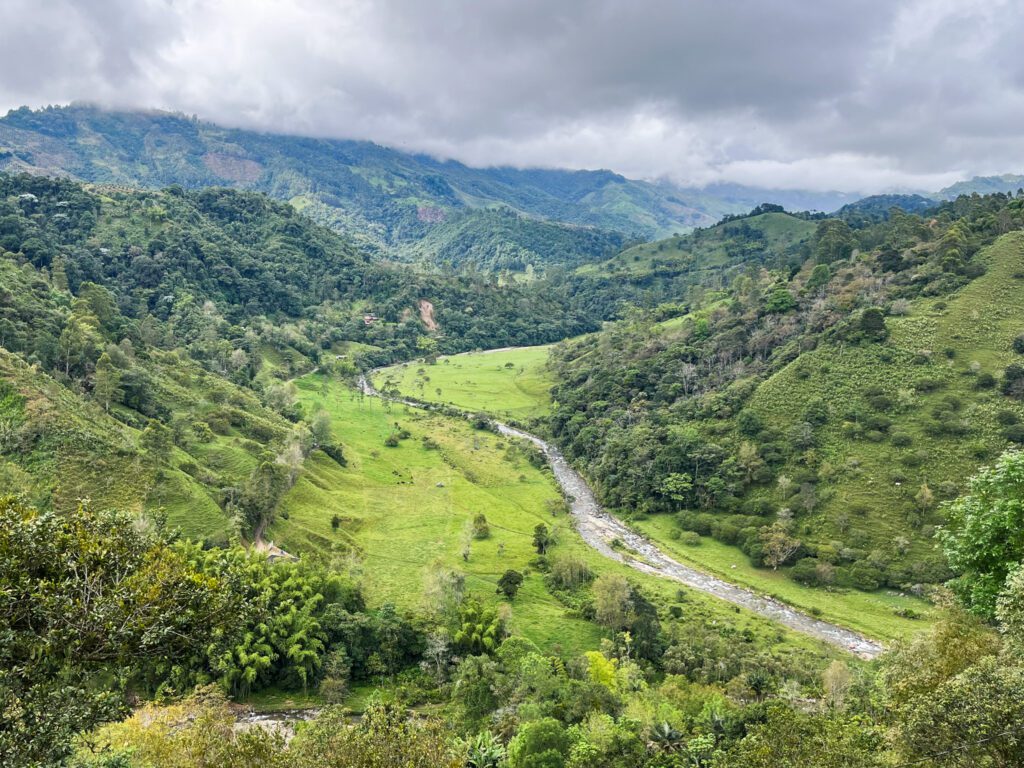 a river and green mountains in salento, colombia