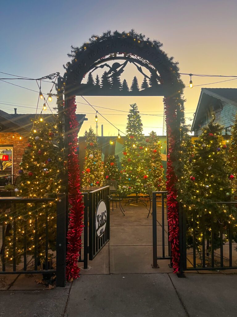 christmas decorations and trees at the gate of a restaurant in mount shasta town