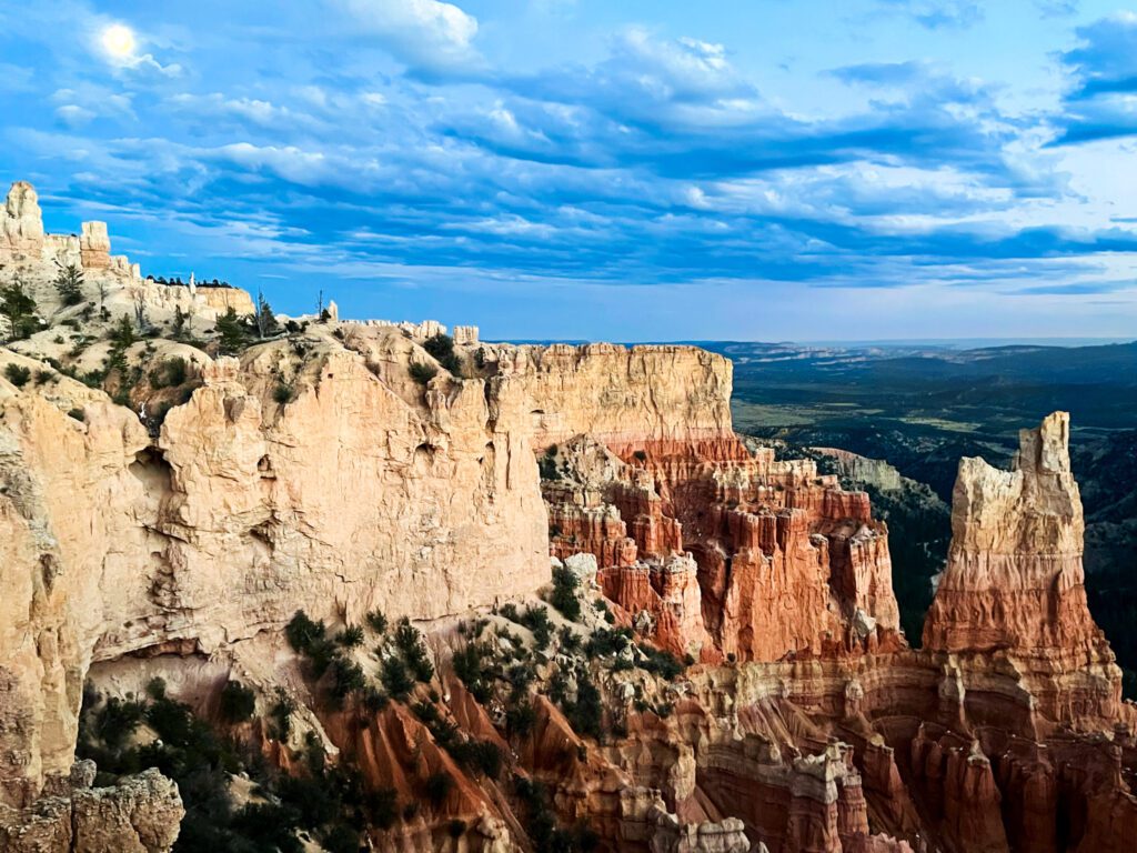 a blue sky above hoodoo formations after sunset in bryce canyon