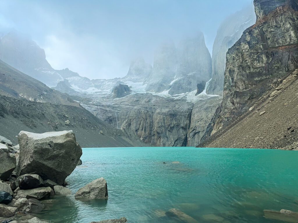 a bright blue alpine lake and craggy mountain towers in Patagonia.