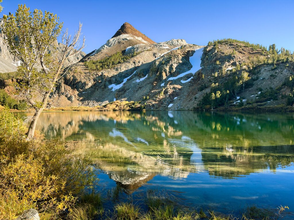 chocolate peak, a conical mountain above a green alpine lake along the bishop pass trail in california's eastern sierra mountains