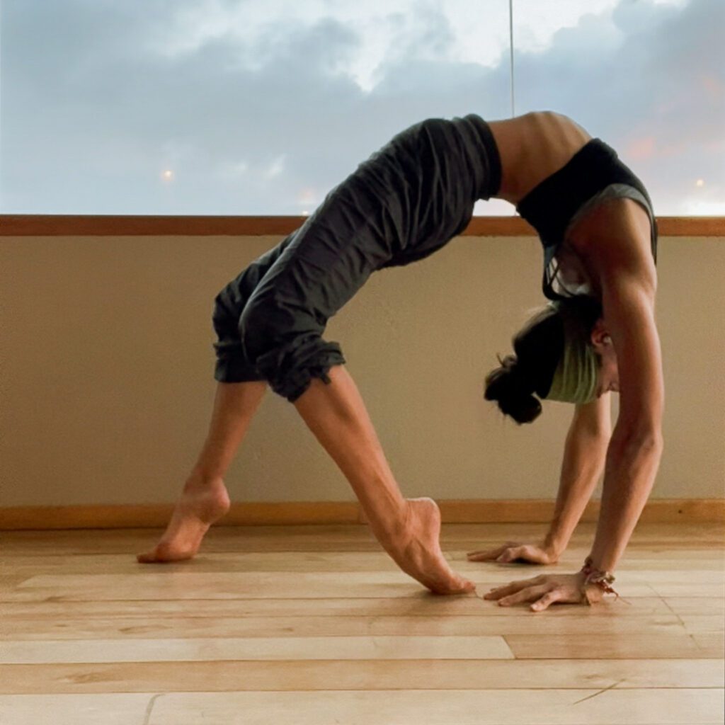 a woman does a backbend in a yoga studio