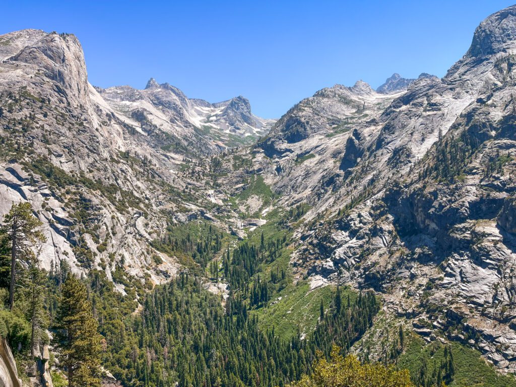 a landscape of dramatic granite mountain formations and a green valley below, as seen on the hamilton lake trail in california