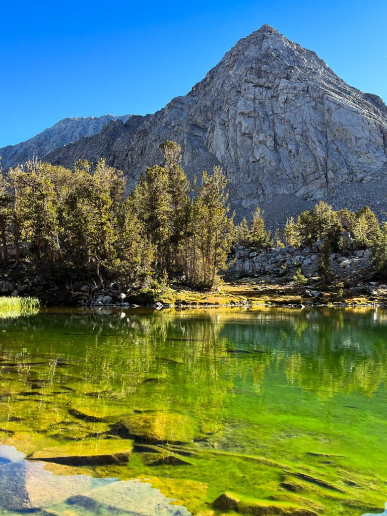 an emerald-colored alpine lake along the little lakes valley to gem lakes hiking trail