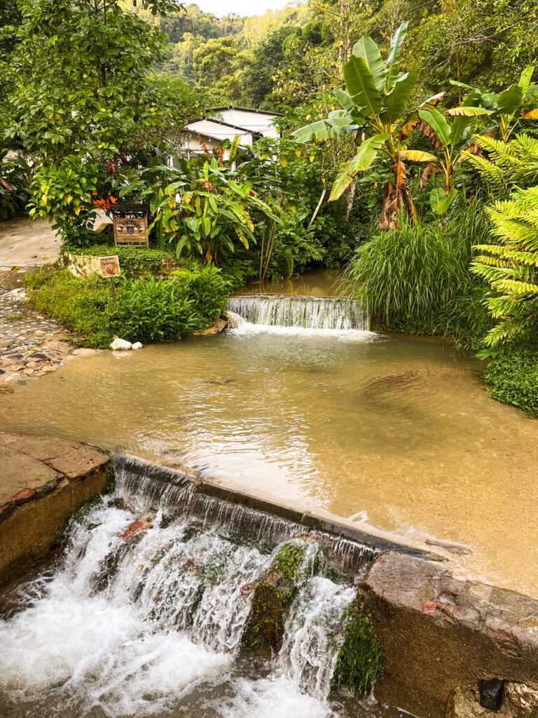 a small waterfall and river in a tropical area