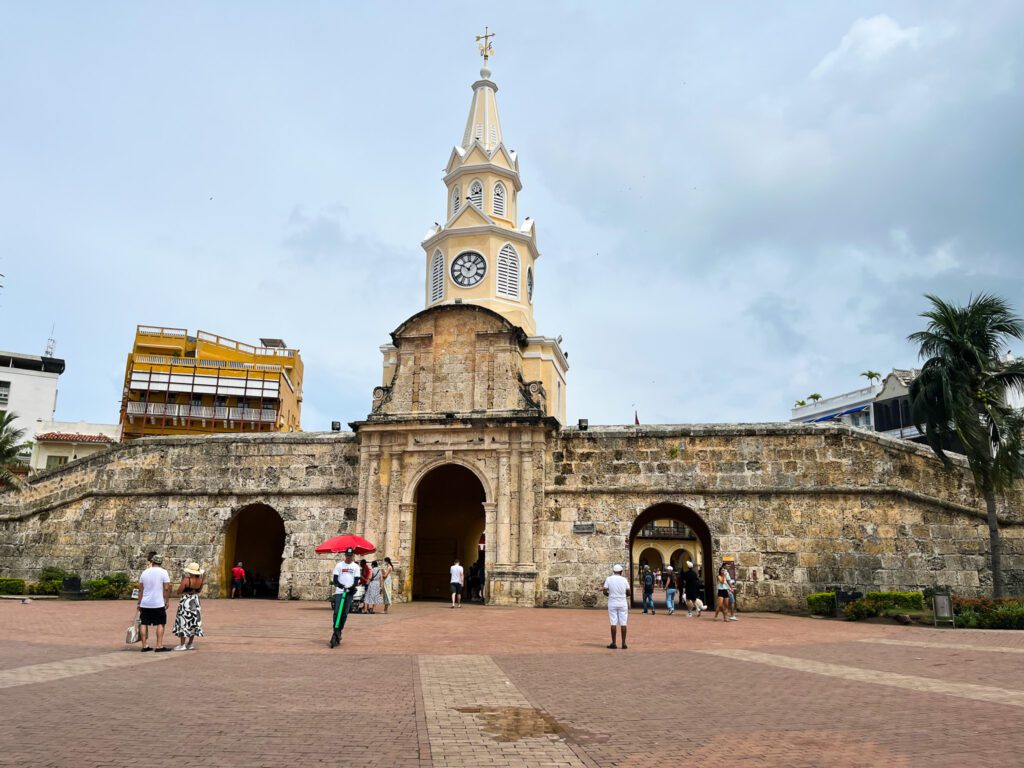 a clock tower and old city wall in cartagena, colombia