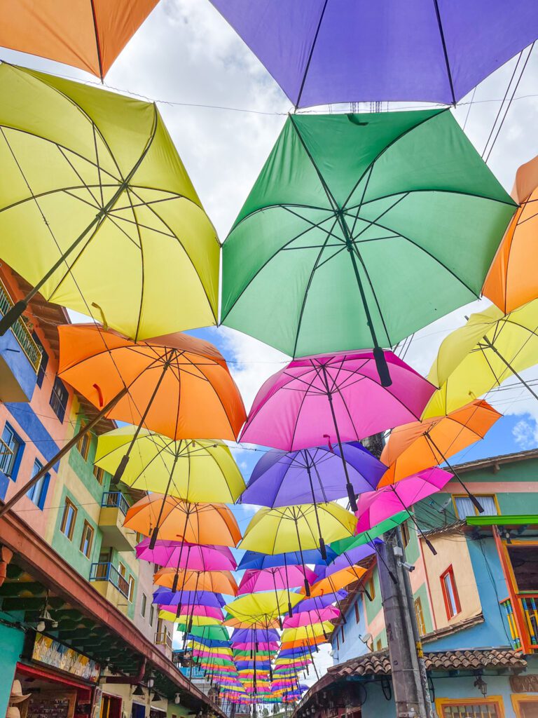 umbrellas suspended over a street in guatape, colombia