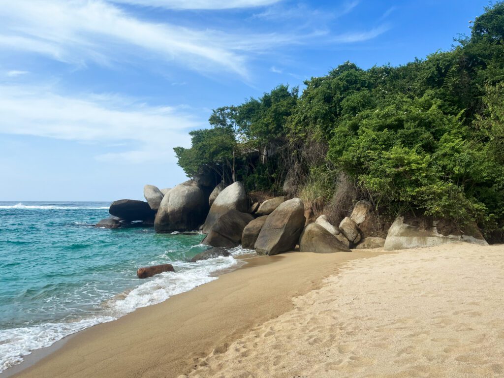a sandy beach with turquoise water in tayrona national park